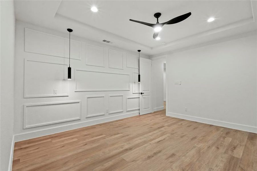 Unfurnished bedroom featuring light wood-style floors, a ceiling fan, a tray ceiling, and recessed lighting Unfurnished bedroom featuring light wood-style floors, a ceiling fan, a tray ceiling, and recessed lighting