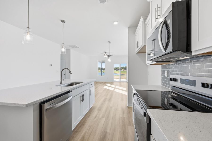 Kitchen featuring appliances with stainless steel finishes, white cabinetry, light stone countertops, and recessed lighting Kitchen featuring appliances with stainless steel finishes, white cabinetry, light stone countertops, and recessed lighting