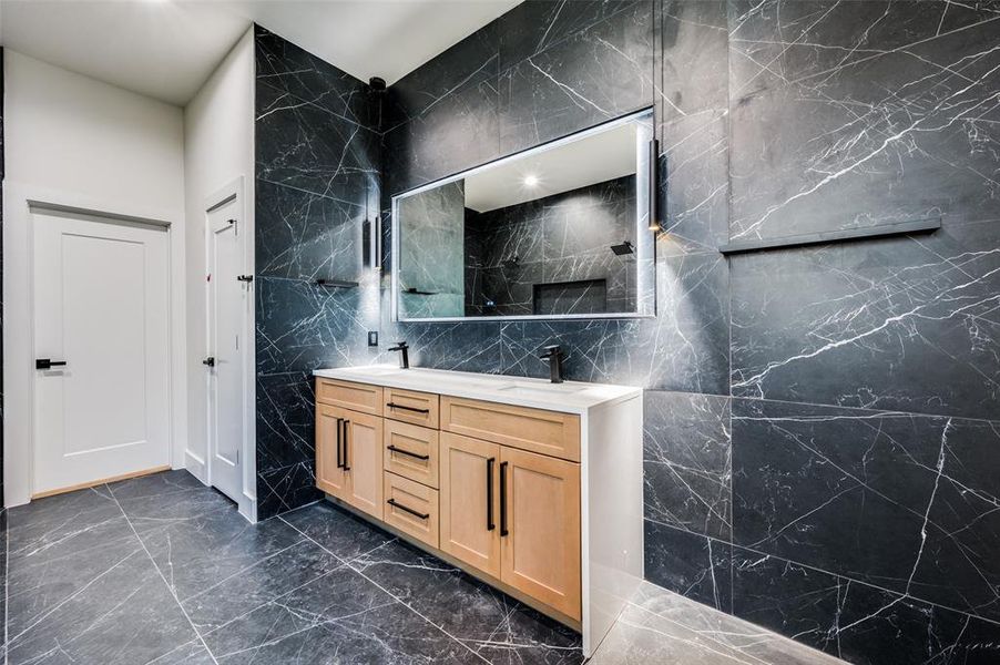 Bathroom featuring vanity and tile walls