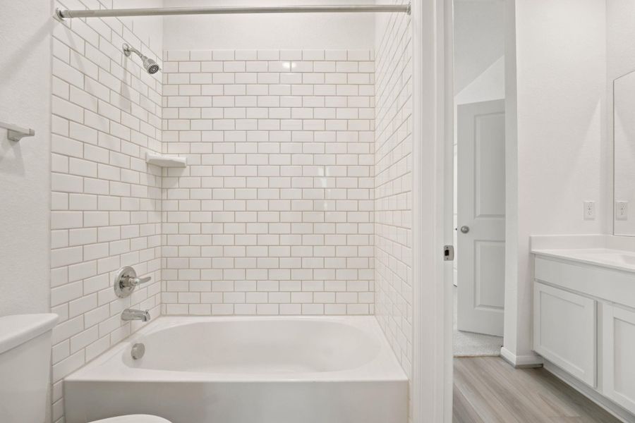 Classic white subway tile lines the shower surround in this crisp secondary bathroom.