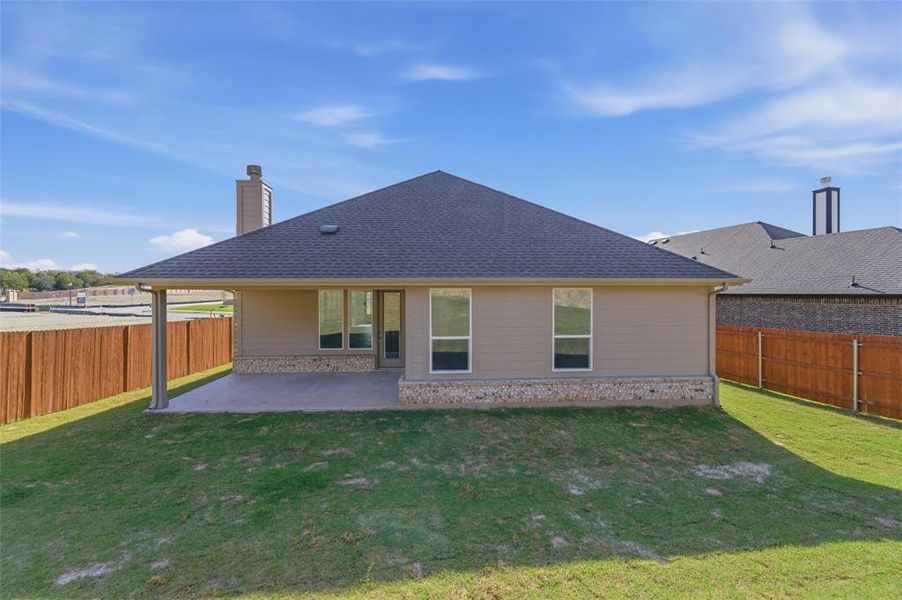 Back of house with a patio, a fenced backyard, a chimney, and roof with shingles