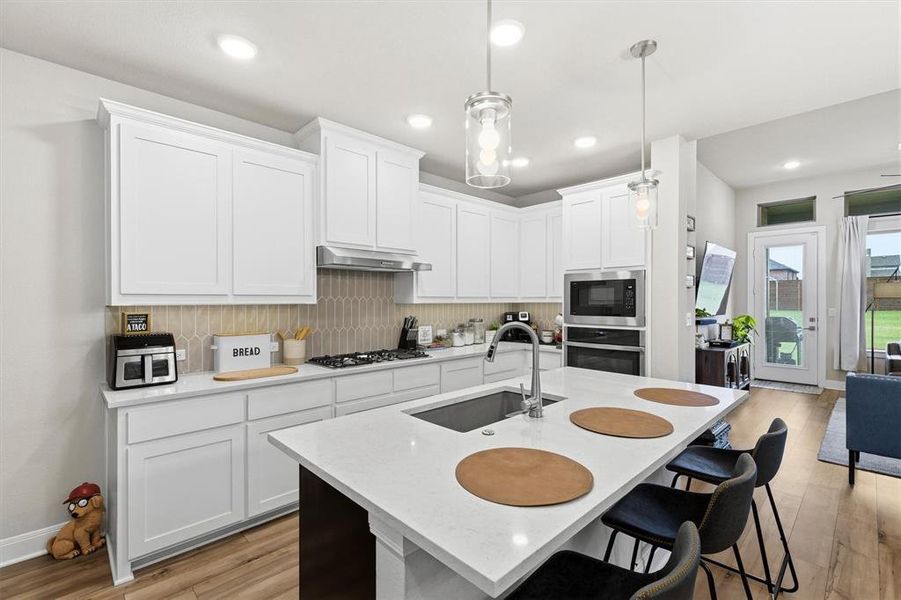 A wall mounted oven, gas cooktop and extra seating in the kitchen A wall mounted oven, gas cooktop and extra seating in the kitchen