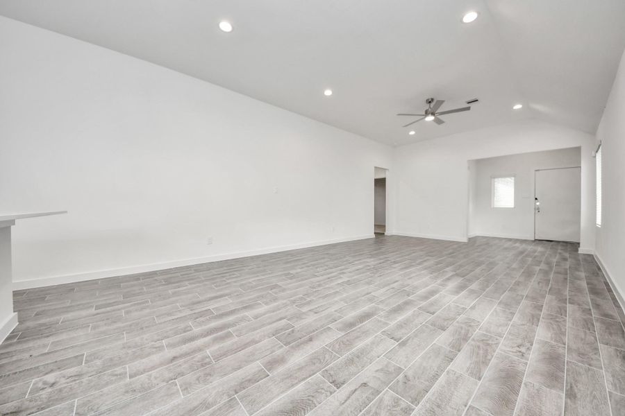 Family room flooded with natural light through the expansive windows.  The premium tile flooring adds a touch of luxury to the space, creating the perfect setting for relaxing moments and cherished gatherings with loved ones.