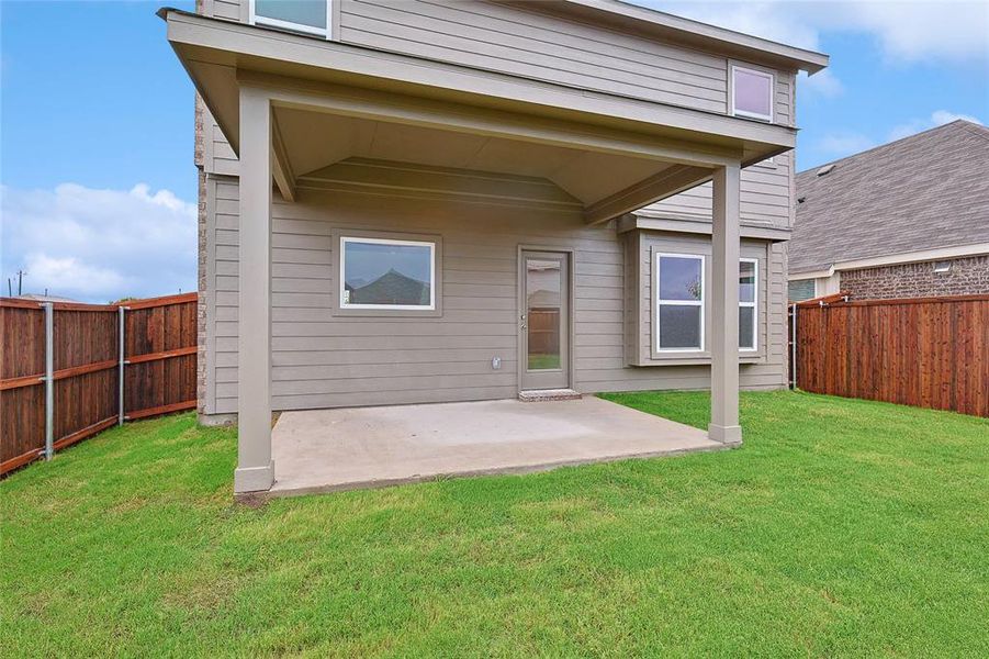 Back of house with a patio and a yard