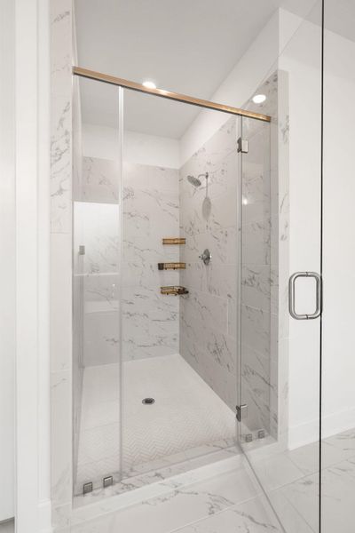 A frameless glass shower enclosure creates an open, spa-like atmosphere.