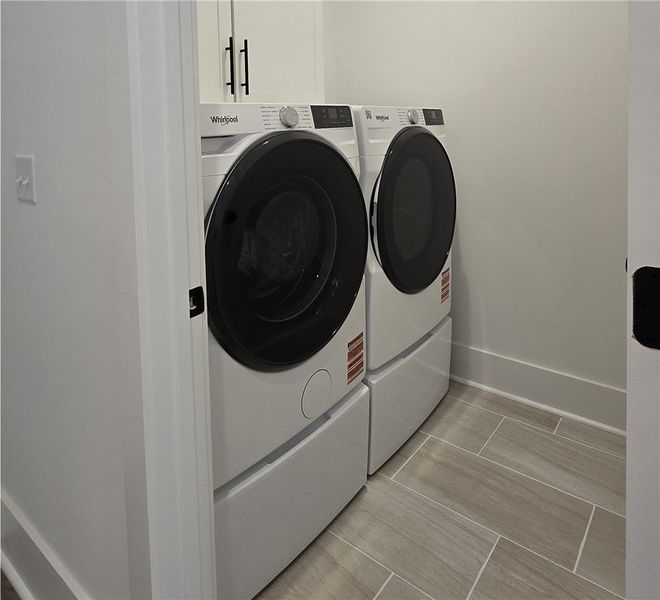 A dedicated laundry room features modern washer an