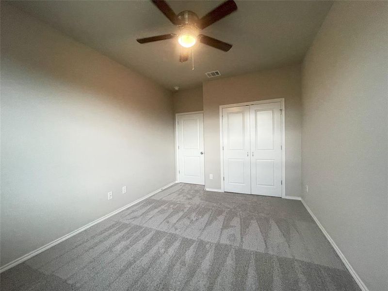 Unfurnished bedroom featuring baseboards, carpet flooring, a closet, and a ceiling fan
