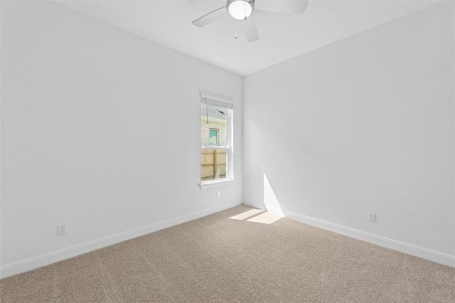 A well-lit bedroom provides ample space and neutral carpeting, creating a tranquil retreat.