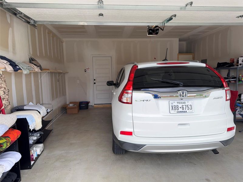 Secure parking within a functional garage, offering convenient internal access and additional shelving.