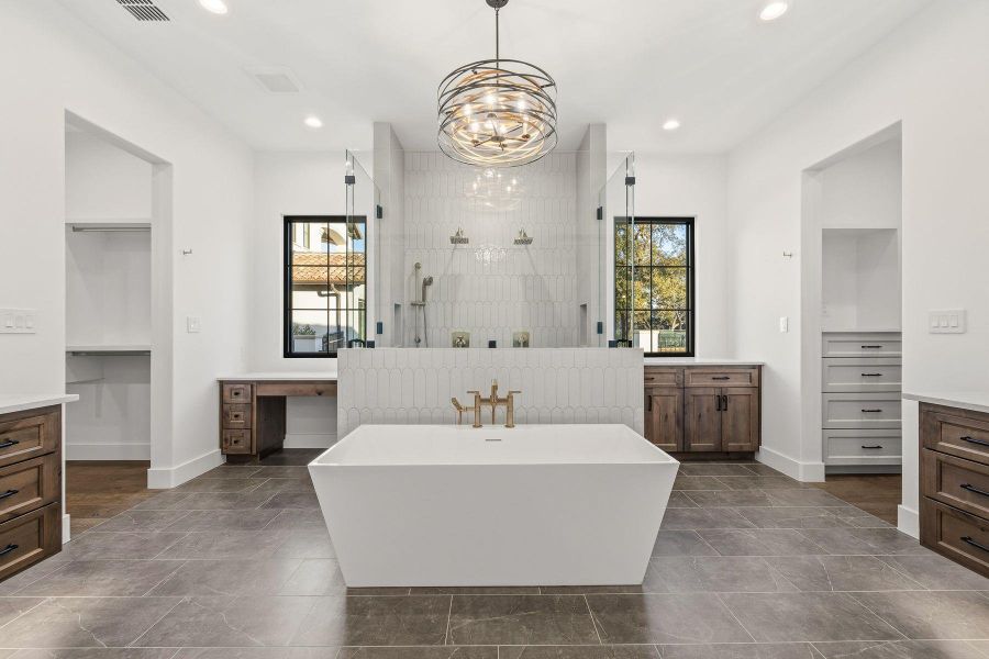 Full bath with vanity, a spacious closet, walk in shower, recessed lighting, and a freestanding tub