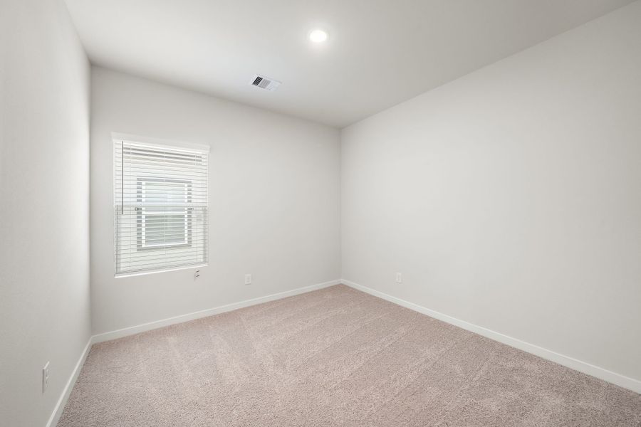 A room with a carpet and a window.