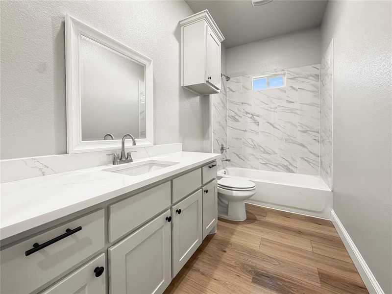 Bathroom featuring a white vanity with an integrated sink, polished chrome faucet, and black hardware