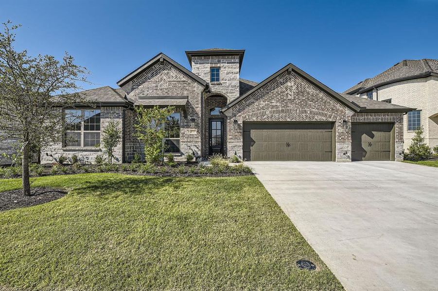 French provincial home with a front yard and a garage