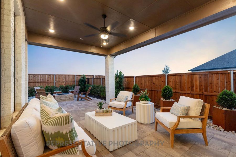 Patio terrace at dusk featuring a patio, an outdoor living space with a fire pit, a fenced backyard, and a ceiling fan