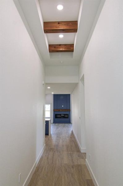 Hall with beamed ceiling, light wood finished floors, and recessed lighting Hall with beamed ceiling, light wood finished floors, and recessed lighting