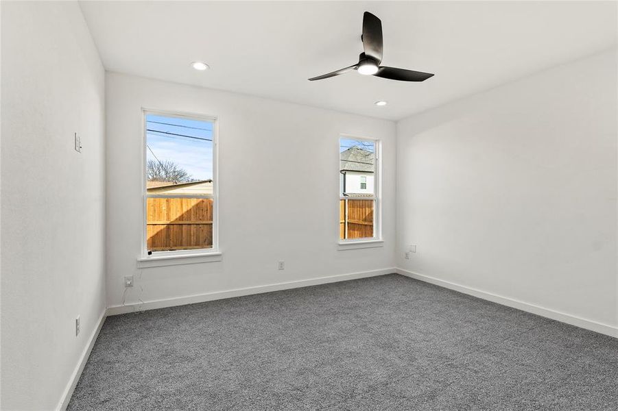 Carpeted spare room with ceiling fan