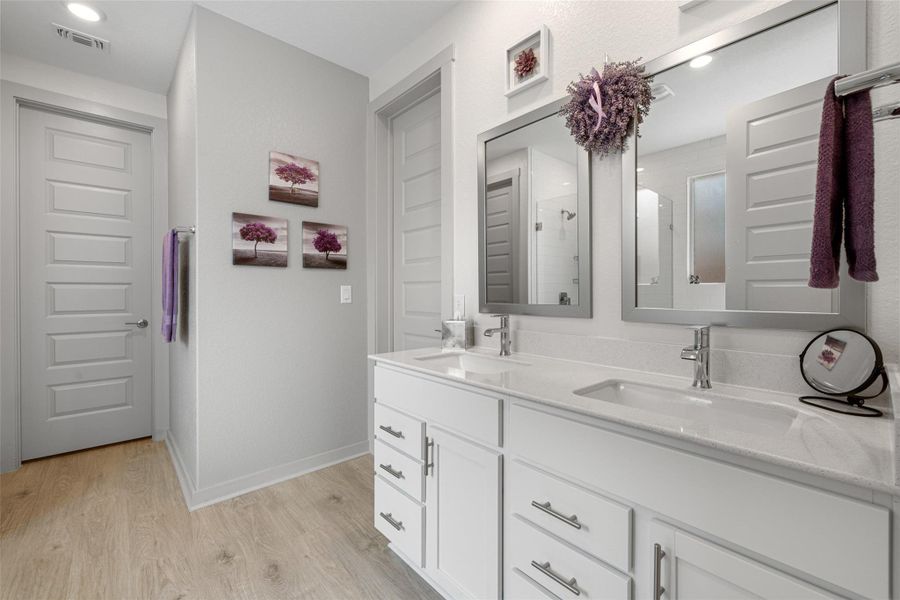 Full bath with a shower stall, light wood-style floors, double vanity, and recessed lighting Full bath with a shower stall, light wood-style floors, double vanity, and recessed lighting