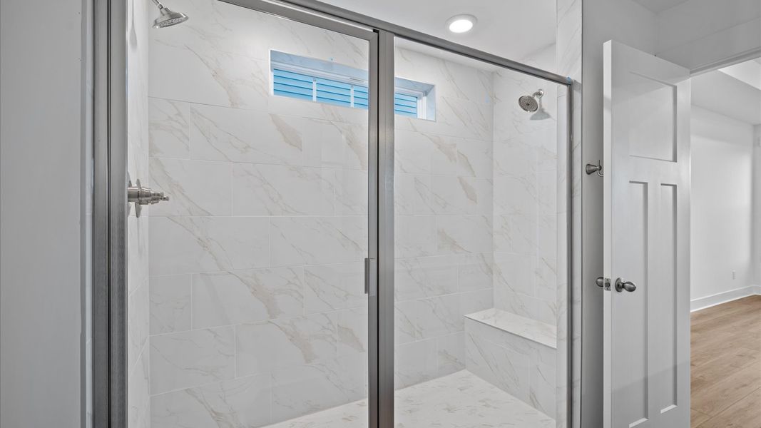 Superior en-suite primary bathroom with stylish dual vanity and tiled walk-in shower crafted with high standards in mind