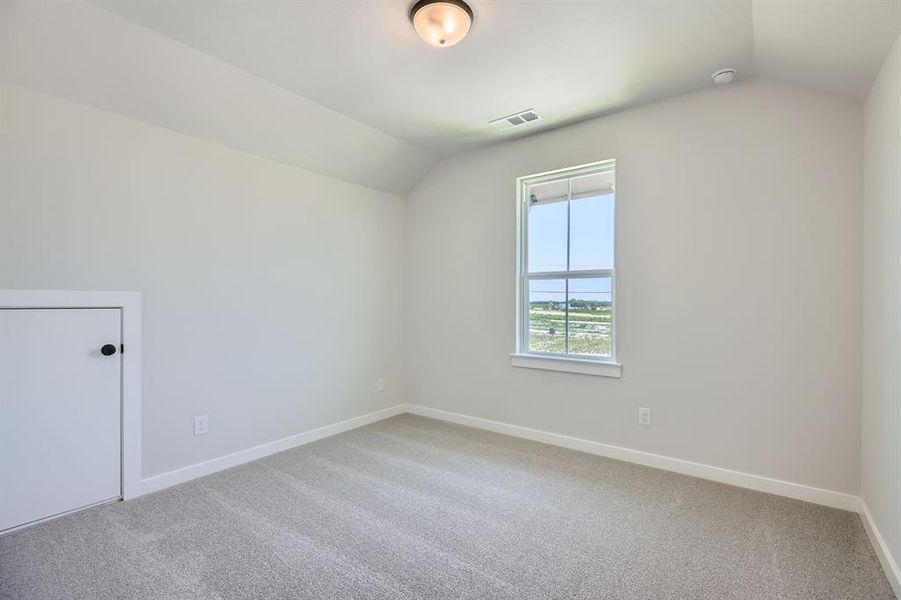 Additional living space with vaulted ceiling, baseboards, and carpet flooring Additional living space with vaulted ceiling, baseboards, and carpet flooring