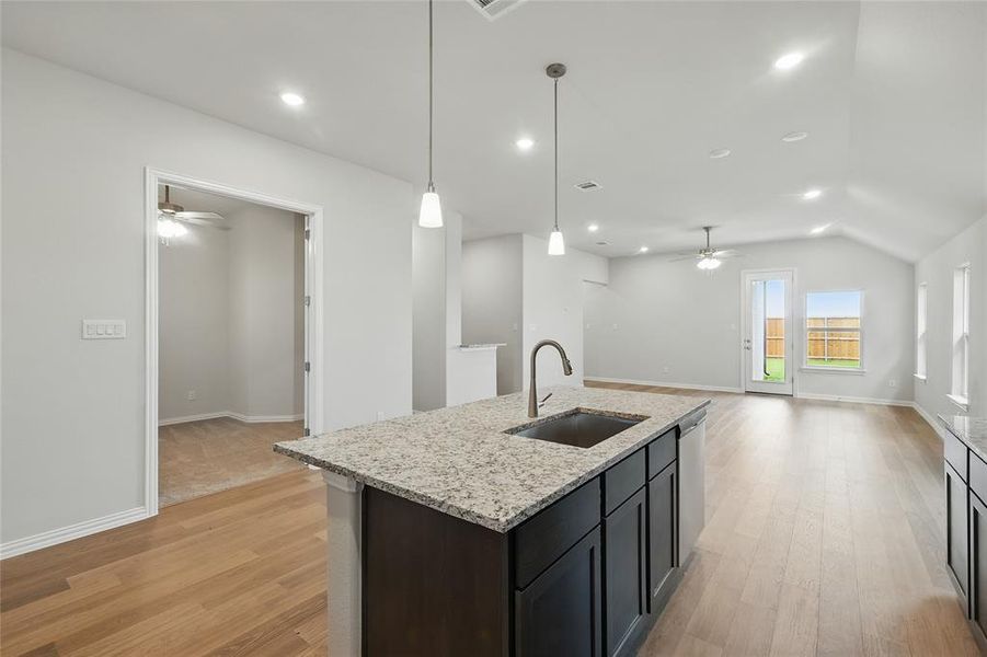 Kitchen with a sink, a ceiling fan, open floor plan, vaulted ceiling, and recessed lighting Kitchen with a sink, a ceiling fan, open floor plan, vaulted ceiling, and recessed lighting