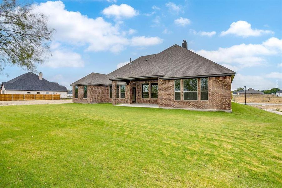 Back of property featuring a patio area and a lawn