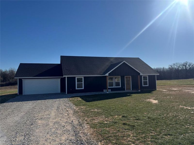 Ranch-style home with a garage and a front lawn