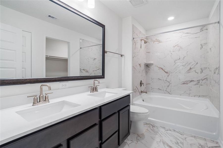 This primary bathroom is definitely move-in ready! Featuring an oversized tub/shower combo, stained cabinets with light countertops and dual vanities, high ceilings, custom paint, sleek and dark modern finishes.