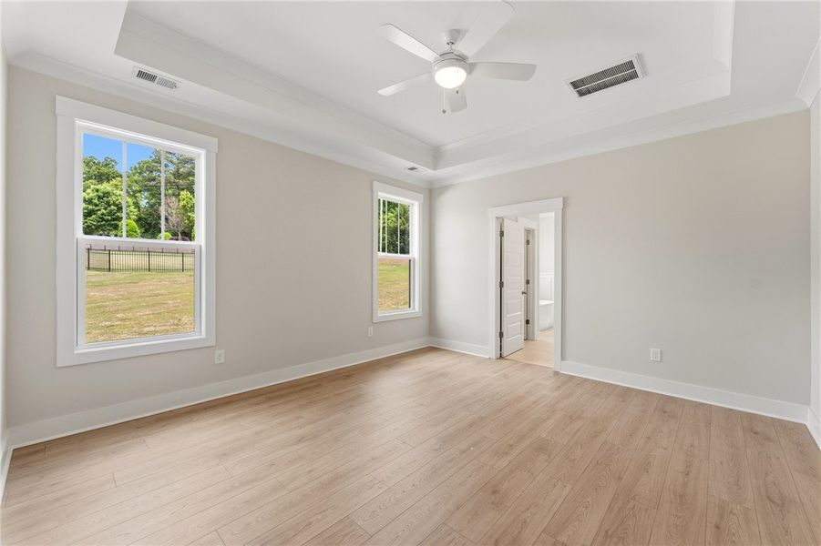 A spacious bedroom features light hardwood floorin