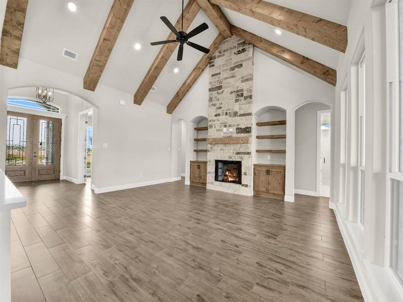 Unfurnished living room featuring high vaulted ceiling, beamed ceiling, baseboards, ceiling fan, and recessed lighting Unfurnished living room featuring high vaulted ceiling, beamed ceiling, baseboards, ceiling fan, and recessed lighting