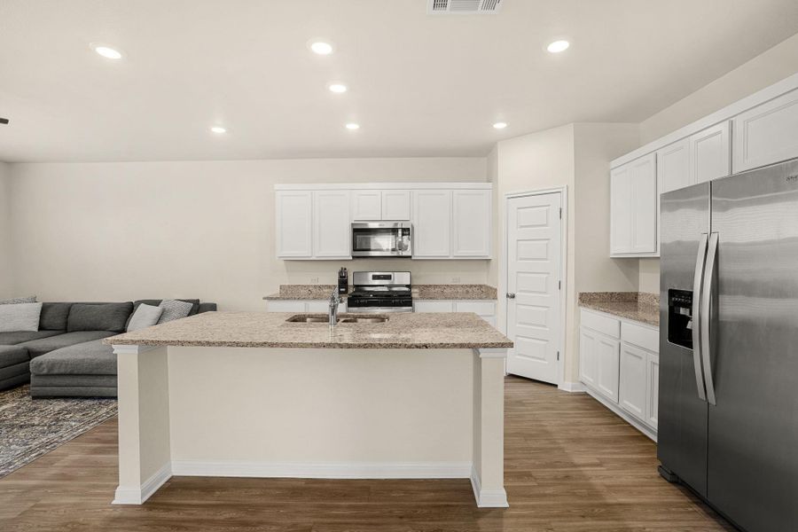 An open concept kitchen features abundant counter space and modern stainless steel appliances.