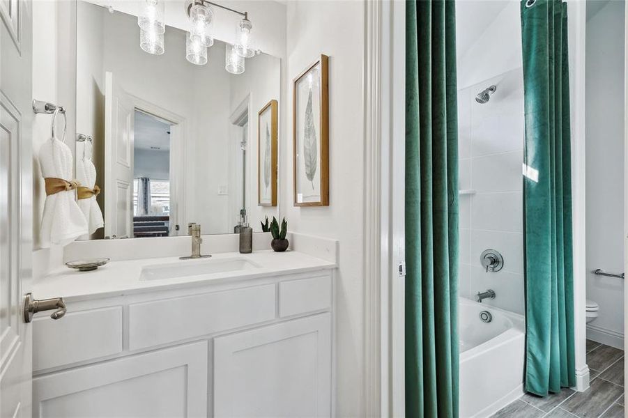 Bathroom featuring a white vanity with an integrated sink, brushed nickel faucet, and overhead linear vanity light
