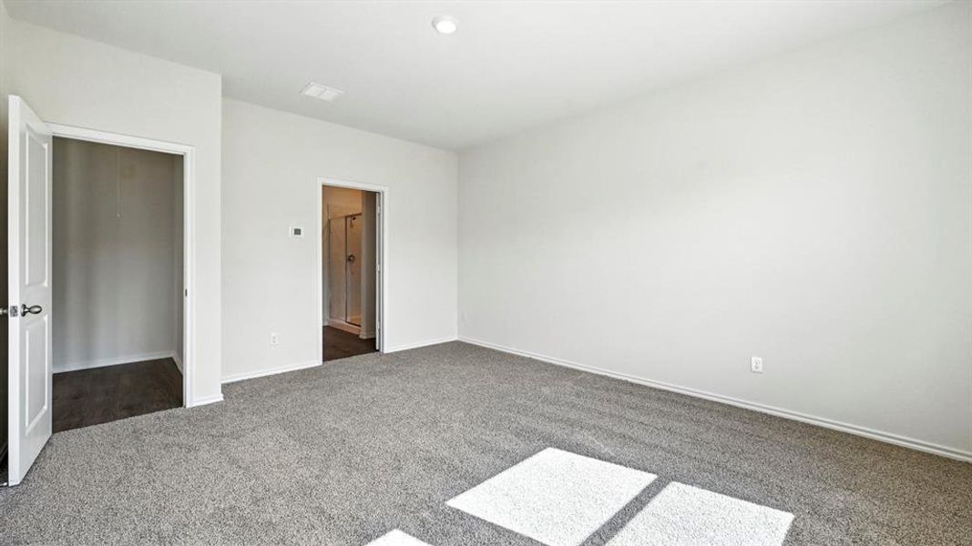 Spacious room featuring light gray carpet flooring and white painted walls