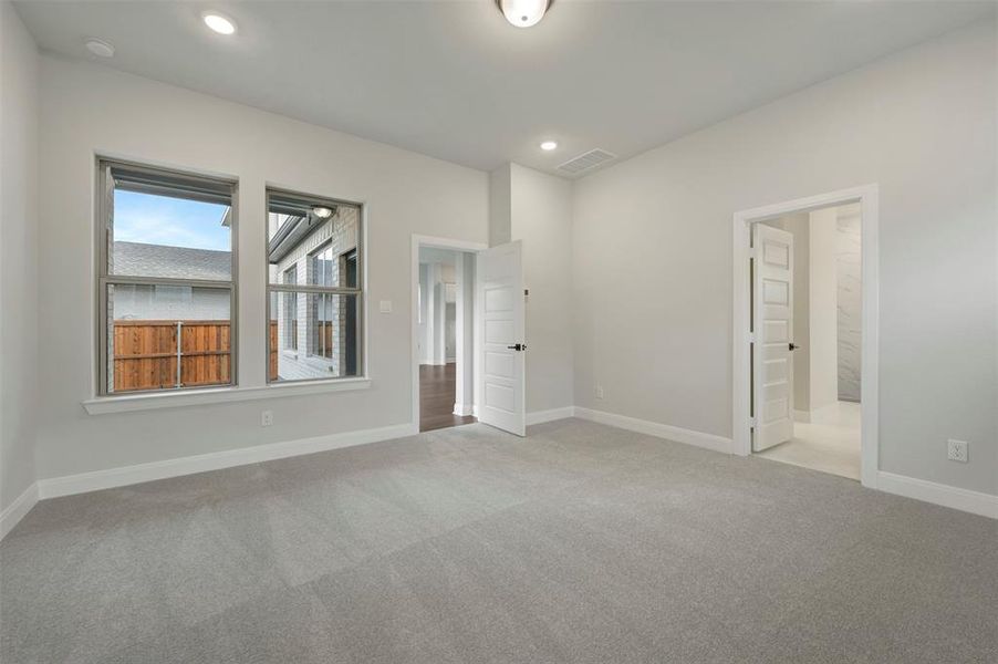 Unfurnished bedroom with light colored carpet and recessed lighting