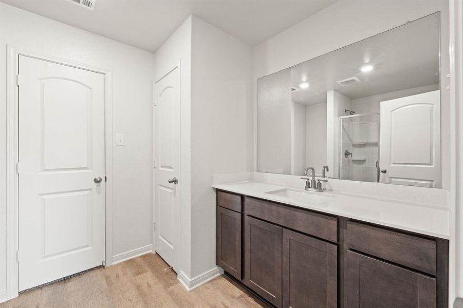 Bathroom with wood-type flooring, vanity, and a shower