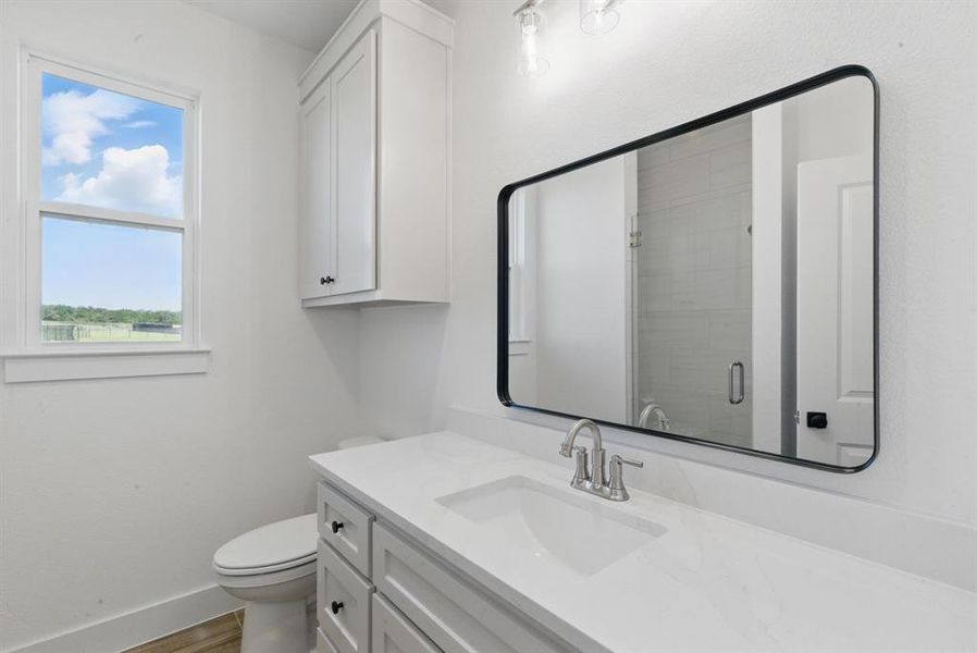 Full bath with vanity, a stall shower, and wood finished floors Full bath with vanity, a stall shower, and wood finished floors