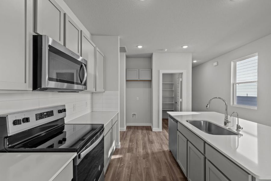 A kitchen with white cabinets.