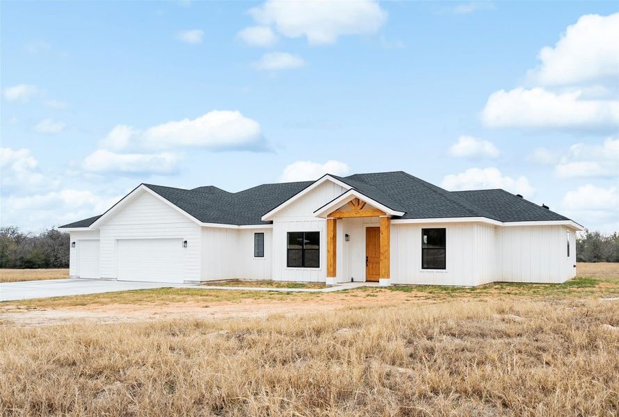 Modern inspired farmhouse featuring roof with shingles, an attached garage, and concrete driveway
