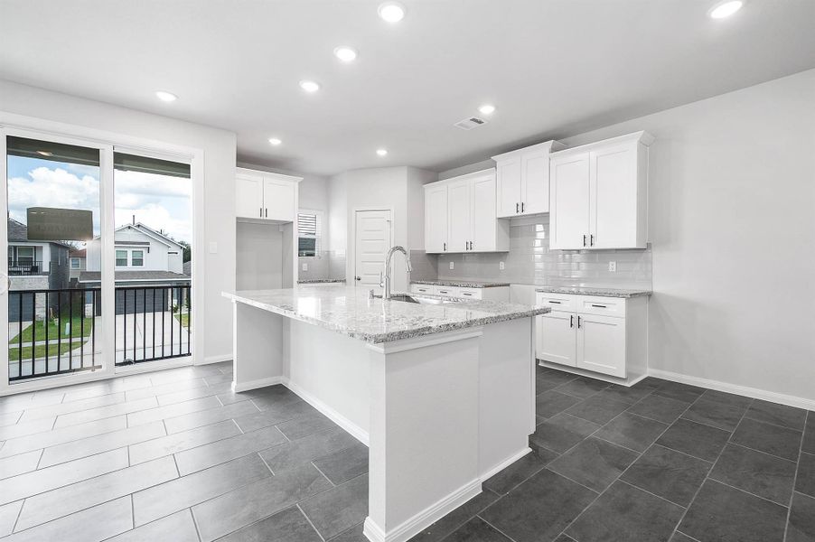 Sunlit and open, this kitchen centers around a spacious island with breakfast bar seating, perfect for everyday meals and effortless entertaining. Sunlit and open, this kitchen centers around a spacious island with breakfast bar seating, perfect for everyday meals and effortless entertaining.