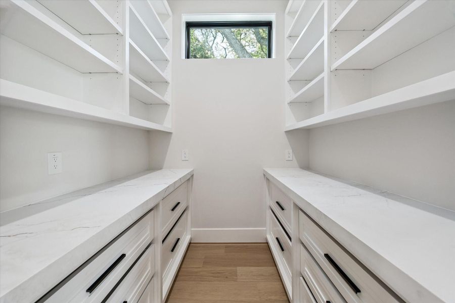 The pantry offers built-in drawers and open shelving, offering optimal organization and easy access to essentials.