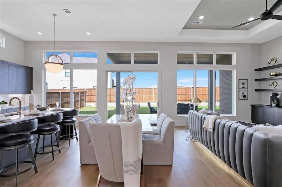 Open-concept living space featuring wood-finish flooring, recessed lighting, and large windows providing abundant natural light
