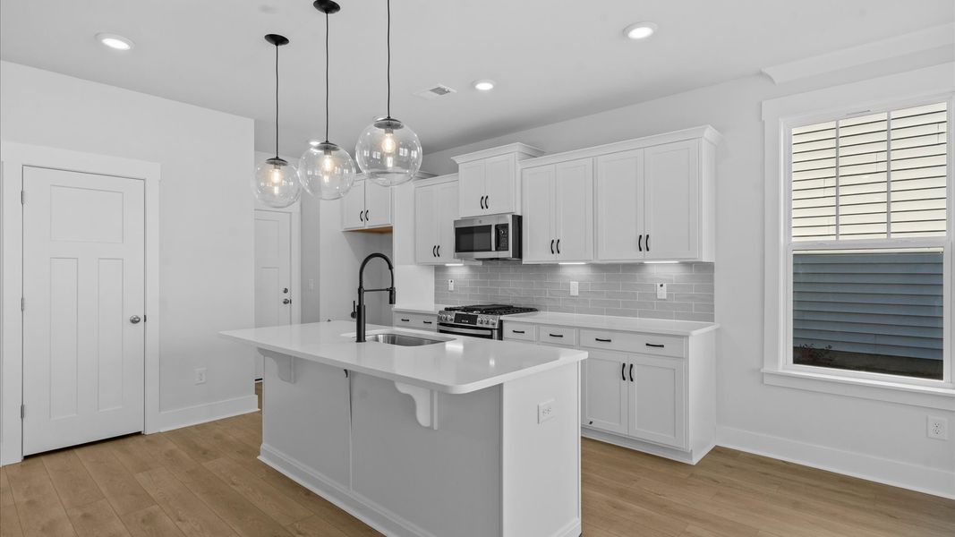 Memorable meals begin in this vibrant kitchen with pendant lighting and a thoughtfully designed island