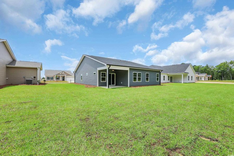 Rear view of property with a patio and a lawn
