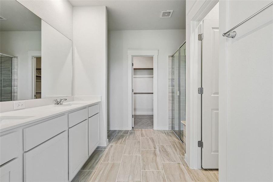 Bathroom with an enclosed shower, vanity, and tile patterned floors