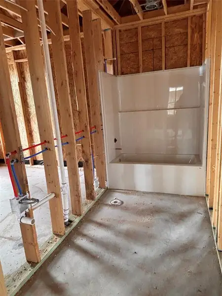 Framed interior space featuring a white acrylic tub and shower surround