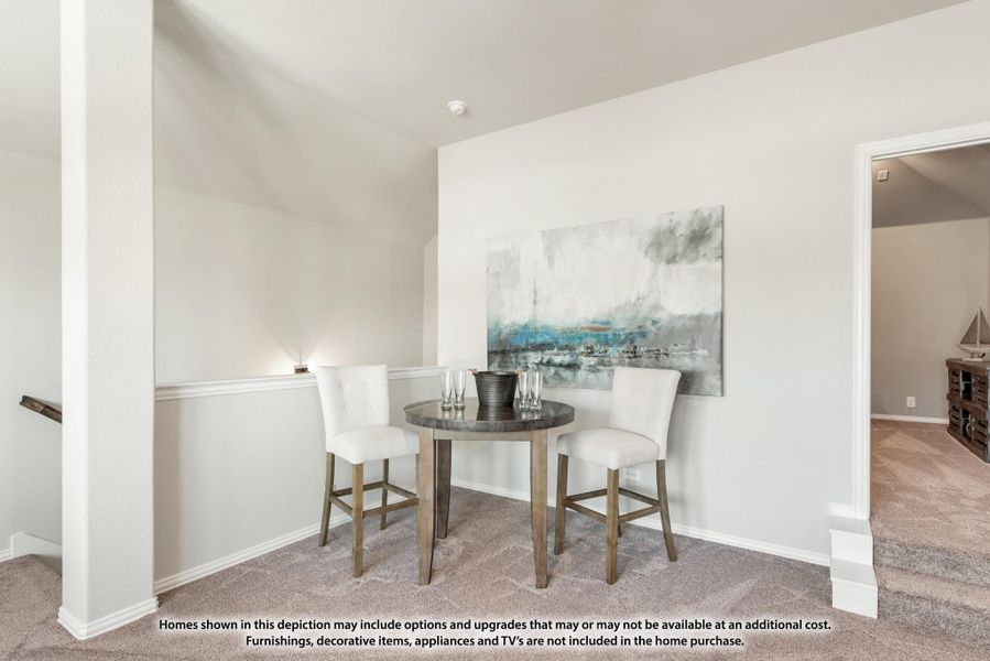 Small dining nook with round dark table, two white chairs, and abstract wall art on beige carpet Small dining nook with round dark table, two white chairs, and abstract wall art on beige carpet