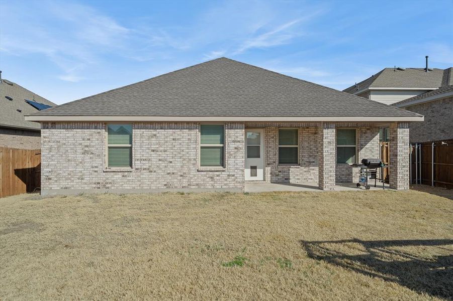 Back of house featuring a fenced backyard, a patio, brick siding, and roof with shingles Back of house featuring a fenced backyard, a patio, brick siding, and roof with shingles