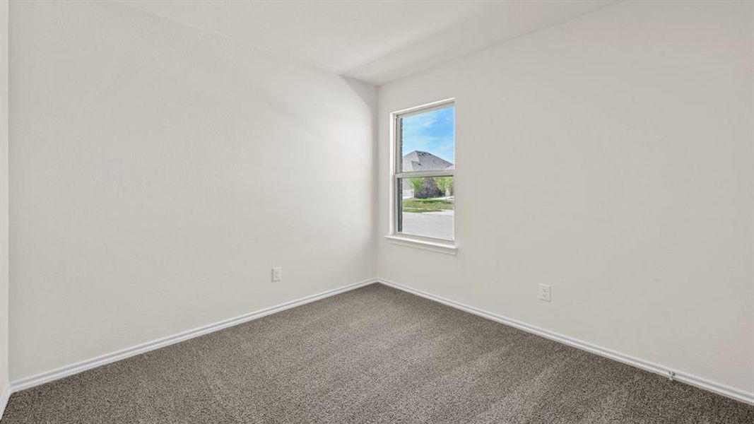 Unfurnished room featuring dark carpet and baseboards