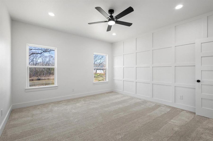 Carpeted empty room featuring ceiling fan