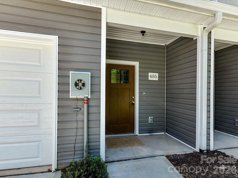 Welcoming covered entry with private front door, modern finishes, and convenient access to the attached garage for everyday ease. Welcoming covered entry with private front door, modern finishes, and convenient access to the attached garage for everyday ease.