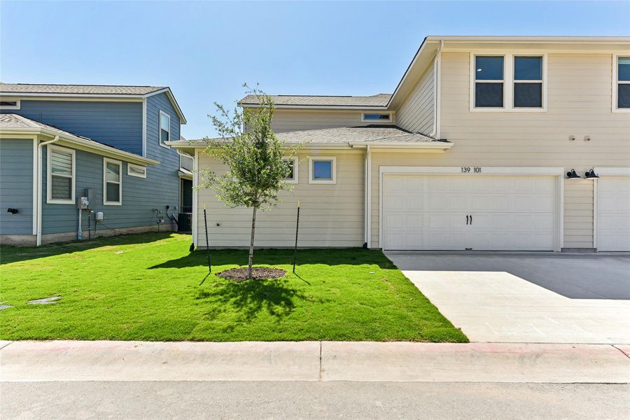 View of front of property featuring an attached garage, driveway, and a front lawn View of front of property featuring an attached garage, driveway, and a front lawn
